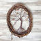 front view vine wreath with brown wire tree of life, displayed against a whitewashed wood background to bring out the rustic beauty